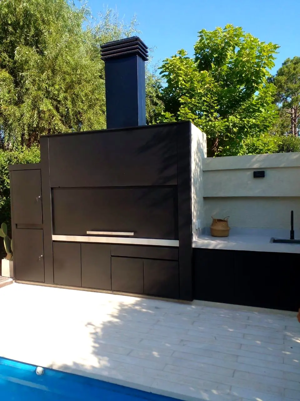 Instalación exterior junto a la pileta con mesada y bacha